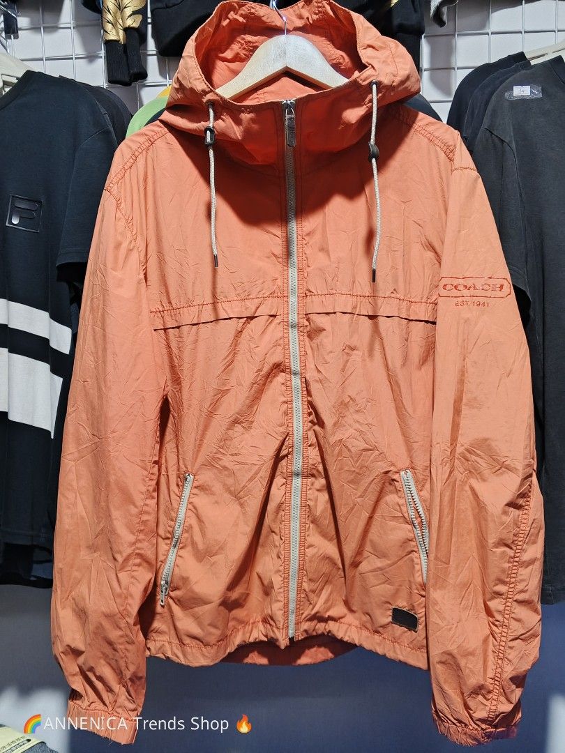 COACH Windbreaker Hoodie Jacket (Category: Coats, Jackets and Outerwear) located in Bulacan. Submitted by annenicathriftthriftlang (Listing ID 1466824168, Image 1). Description: 🧡 COACH Windbreaker Hoodie Jacket - EST. 1941 🧡 RARE FIND! Terracotta / Salmon Pink colorway 😍 📌 DIMES: Size on tag: XL / TG Best fit: Large to XL Length: ~27.5 Width / Pit to Pit: ~23.5 Color: Terracotta / Peach Orange ✅ DETAILS: - Hoodie with adjustable drawstring -