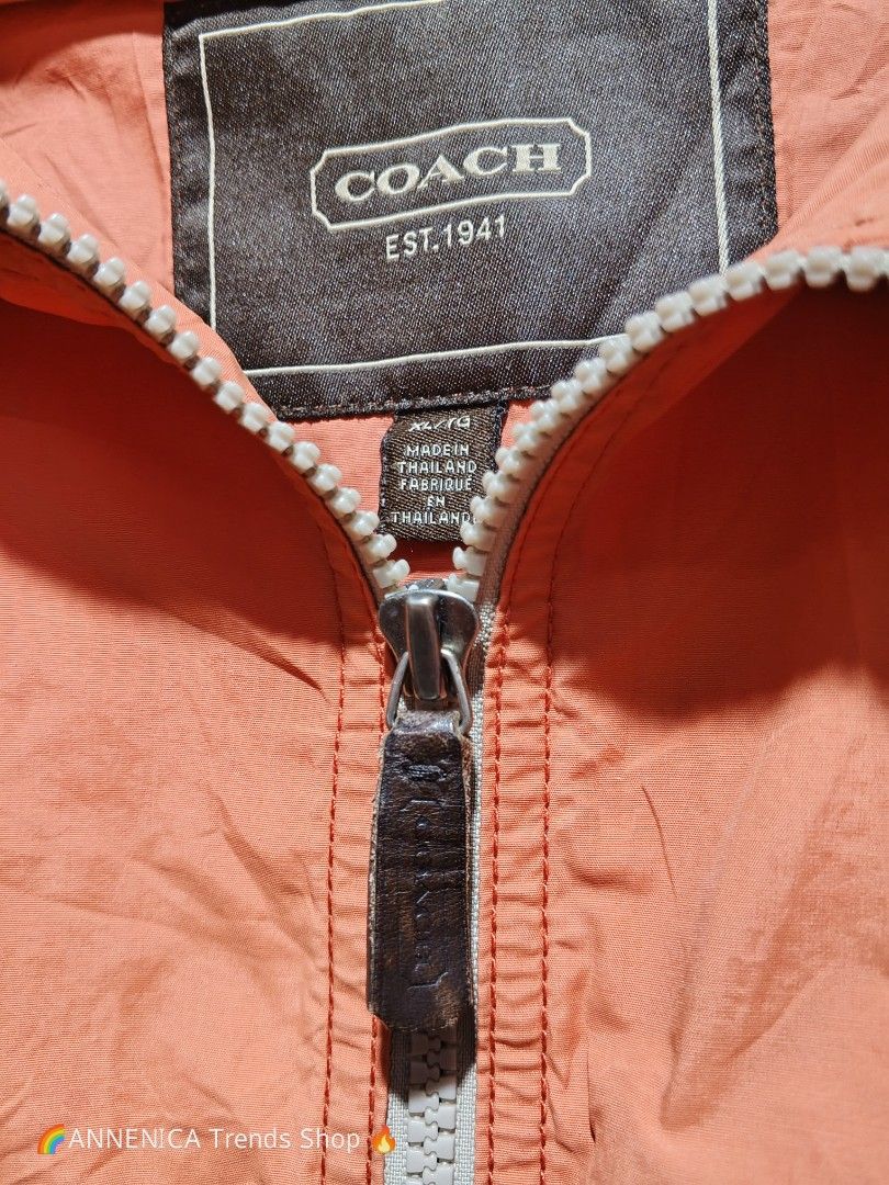COACH Windbreaker Hoodie Jacket (Category: Coats, Jackets and Outerwear) located in Bulacan. Submitted by annenicathriftthriftlang (Listing ID 1466824168, Image 2). Description: 🧡 COACH Windbreaker Hoodie Jacket - EST. 1941 🧡 RARE FIND! Terracotta / Salmon Pink colorway 😍 📌 DIMES: Size on tag: XL / TG Best fit: Large to XL Length: ~27.5 Width / Pit to Pit: ~23.5 Color: Terracotta / Peach Orange ✅ DETAILS: - Hoodie with adjustable drawstring -