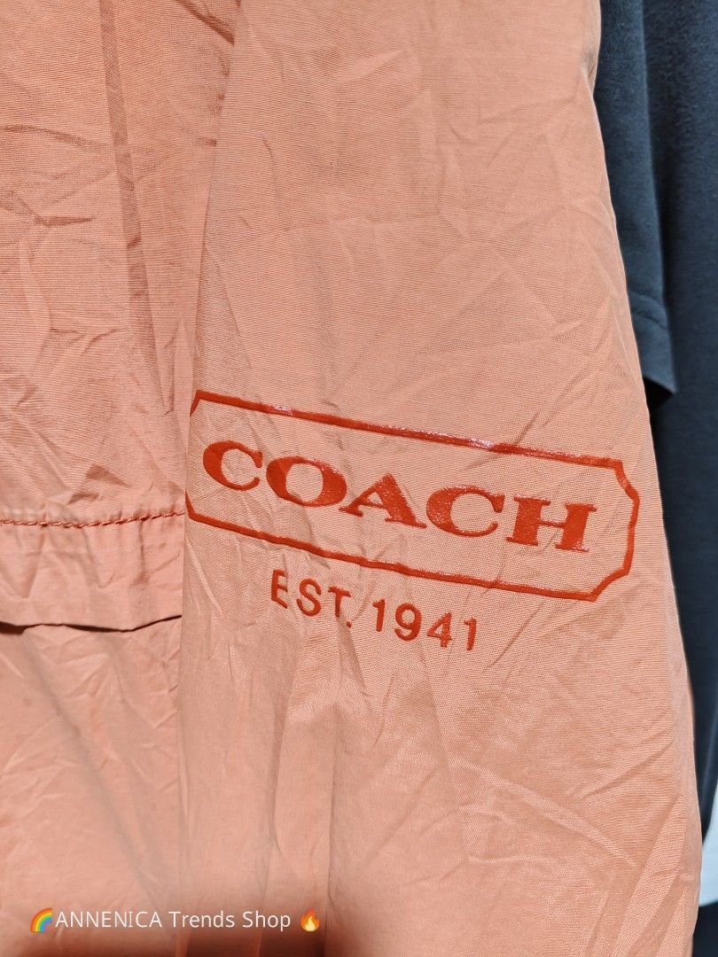 COACH Windbreaker Hoodie Jacket (Category: Coats, Jackets and Outerwear) located in Bulacan. Submitted by annenicathriftthriftlang (Listing ID 1466824168, Image 3). Description: 🧡 COACH Windbreaker Hoodie Jacket - EST. 1941 🧡 RARE FIND! Terracotta / Salmon Pink colorway 😍 📌 DIMES: Size on tag: XL / TG Best fit: Large to XL Length: ~27.5 Width / Pit to Pit: ~23.5 Color: Terracotta / Peach Orange ✅ DETAILS: - Hoodie with adjustable drawstring -