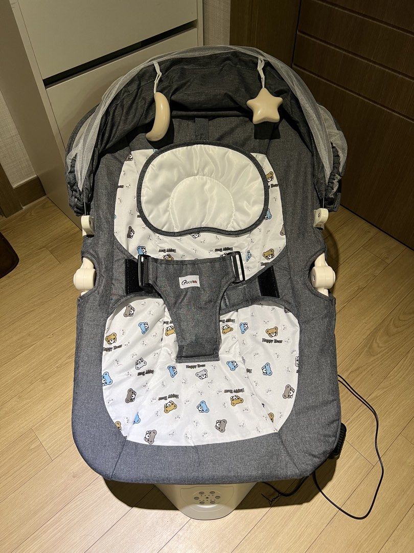 Cocobb Electric Baby Rocker (Category: Cots & Cribs) located in Angeles City. Submitted by myshoppingaccount24 (Listing ID 1466824621, Image 1). Description: - Brand: Cocobb Electric Baby Rocker (Grey) - Comfort & Safety: 3-point safety harness and cozy inner seat pad with a cute teddy bear pattern - Accessories: Includes a protective canopy, mesh mosquito net, and hanging star & moon toys - Design: Stylish white curved base - Power: Includes att
