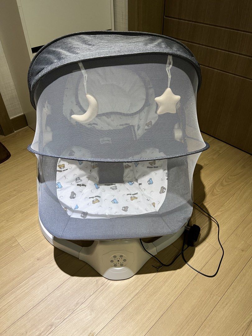 Cocobb Electric Baby Rocker (Category: Cots & Cribs) located in Angeles City. Submitted by myshoppingaccount24 (Listing ID 1466824621, Image 2). Description: - Brand: Cocobb Electric Baby Rocker (Grey) - Comfort & Safety: 3-point safety harness and cozy inner seat pad with a cute teddy bear pattern - Accessories: Includes a protective canopy, mesh mosquito net, and hanging star & moon toys - Design: Stylish white curved base - Power: Includes att