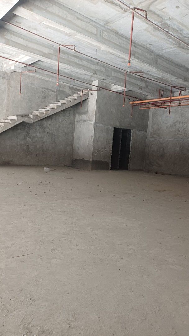 Commercial Space CBD ORTIGAS Pasig City (Category: Construction & Building Materials) located in Manila. Submitted by jo.caro1 (Listing ID 1466925850, Image 3). Description: Unfurnished commercial unit on the ground floor. Large open layout with raw concrete walls, high ceilings, and exposed pipes. Large glass storefront windows facing the street. Staircase leading down to a lower level area. Lots of natural light from the front facade. Great loc