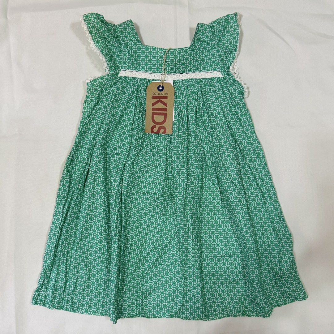 Cotton On Kids Green Patterned Dress (Category: Babies & Kids Fashion) located in Paranaque City. Submitted by dionne_bird (Listing ID 1466929359, Image 1). Description: - Brand: Cotton On Kids - Condition: Brand new with original tag attached - Design: Green patterned dress with white lace trim on the square neckline, sleeves, and front yoke - Details: Ruffle flutter sleeves and a loose, flared skirt - Perfect for casual wear or special occasion