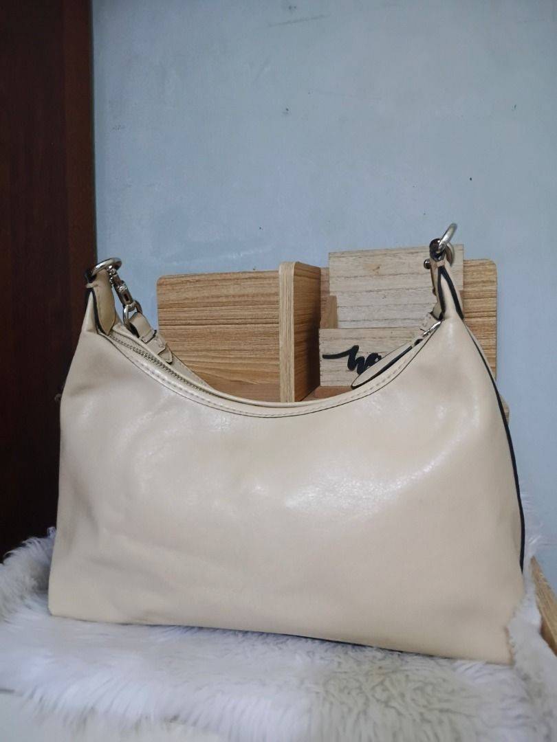 Cream Hobo Shoulder Bag with Silver Hardware (Category: Shoulder Bags) located in Lucena. Submitted by gracious_chin0436 (Listing ID 1466786758, Image 2). Description: - Color: Cream - Style: Curved hobo shoulder bag with top zipper closure - Hardware: Silver-tone with matching detachable charm hangtag - Interior: Clean lining with a flat structured base - Capacity: Spacious enough for all your daily essentials with minimal flaw on corners back p