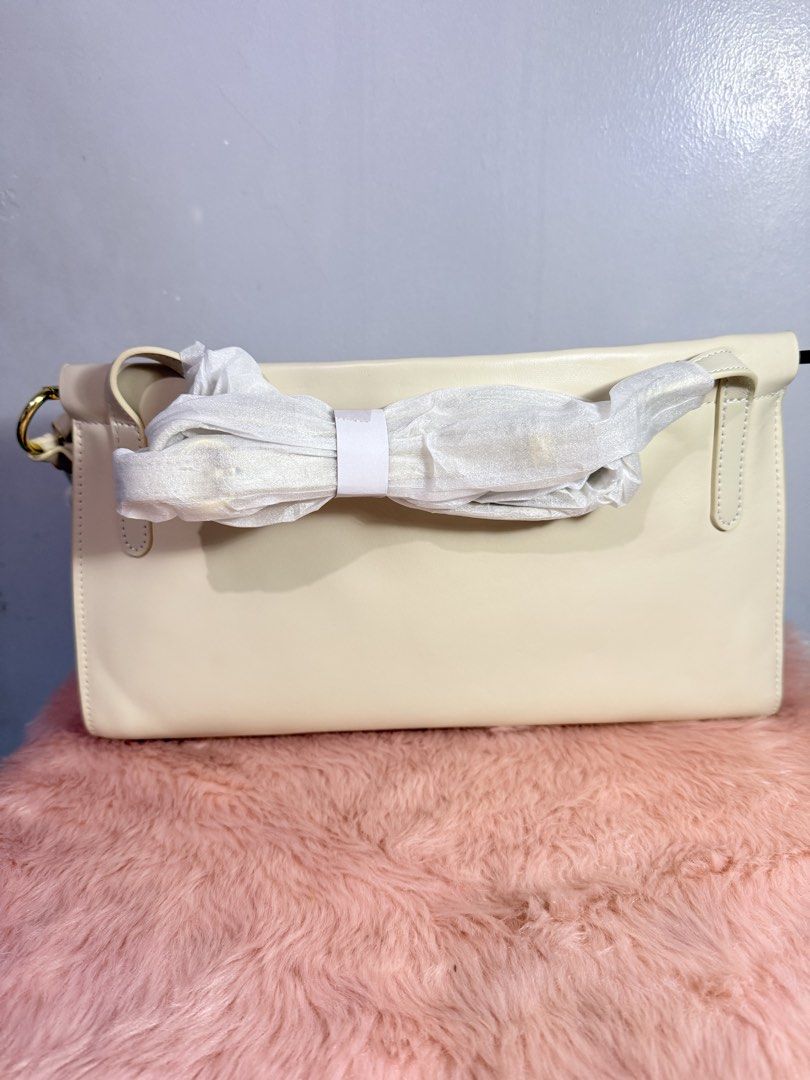 Cream Leather Shoulder Bag with Gold Hardware (Category: Shoulder Bags) located in Quezon City. Submitted by shaberbree (Listing ID 1466913369, Image 3). Description: - Color/Material: Premium cream leather with a structured shape - Hardware: Elegant gold-tone accents, dual side rings, and zipper pulls - Interior: Fully lined with a convenient inner zip pocket - Condition: Brand new and unused - Extras: Strap still wrapped in protective paper and