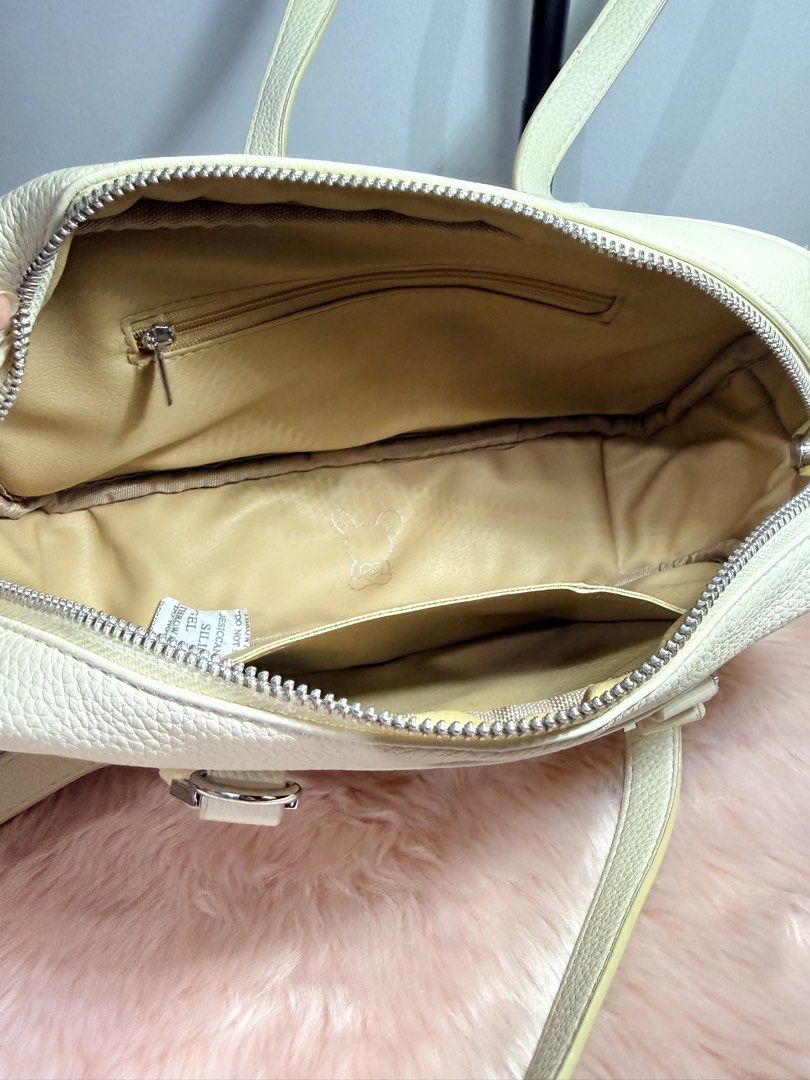 Cream Pebble Leather Shoulder Bag Tote (Category: Shoulder Bags) located in Quezon City. Submitted by shaberbree (Listing ID 1466907320, Image 2). Description: - Material: Cream textured pebble leather - Hardware: Silver-tone - Design: Structured rectangular shape with dual top carry handles - Closure: Top zip closure - Interior: Beige fabric-lined with 1 zipper pocket and open slip pockets - Branding: Subtle metallic ribbon/bow logo emblem on th