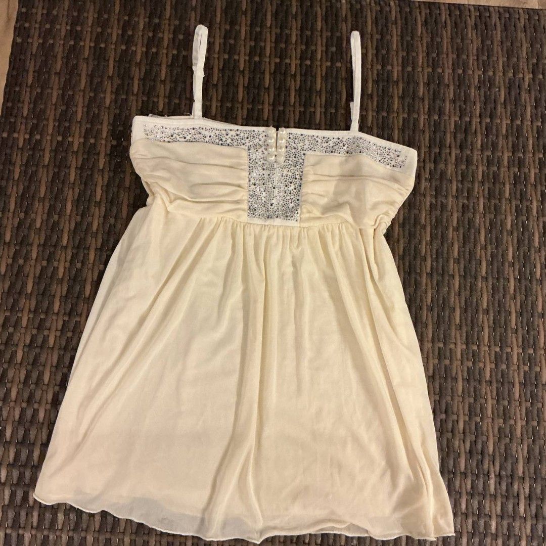Cream Rhinestone Embellished Cami Top Spaghetti Strap (Category: Sleeveless) located in Iloilo. Submitted by xya.xoxo28 (Listing ID 1466833551, Image 1). Description: - Color: Cream - Style: Cami top with thin spaghetti straps and a flowy gathered fit - Details: Elegant rhinestone and pearl embellishments on the upper chest - Comfort: Soft, lightweight, and easy to wear - Versatility: Perfect for both casual daytime looks and stylish nights out.
