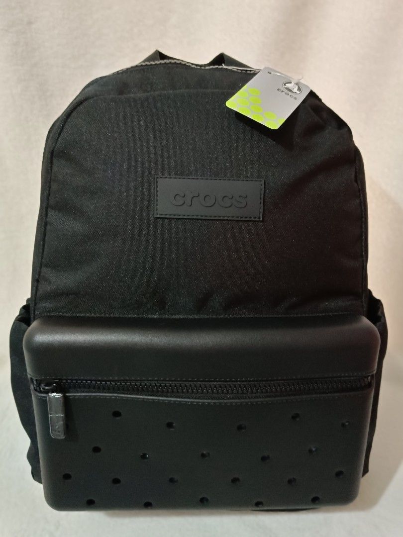 Crocs Black Backpack with Jibbitz Holes (Category: Backpacks) located in Quezon City. Submitted by shinereign (Listing ID 1466843854, Image 3). Description: - Brand new with original store tags attached - Color: Classic Black - Signature perforated front pocket design - Croslite-inspired texture details with embossed logo patch - Padded mesh back panel featuring the Crocs alligator mascot logo - Adjustable shoulder straps with branded strap keepe