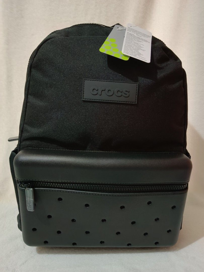 Crocs Black Backpack with Jibbitz Holes (Category: Backpacks) located in Quezon City. Submitted by shinereign (Listing ID 1466843854, Image 1). Description: - Brand new with original store tags attached - Color: Classic Black - Signature perforated front pocket design - Croslite-inspired texture details with embossed logo patch - Padded mesh back panel featuring the Crocs alligator mascot logo - Adjustable shoulder straps with branded strap keepe