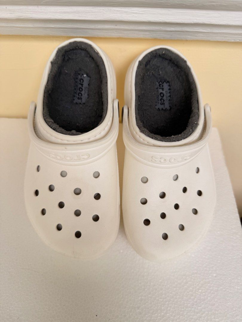 Crocs Classic White C13 (Dual Crocs Comfort) (Category: Babies & Kids Fashion) located in Manila. Submitted by dashcash (Listing ID 1466817230, Image 3). Description: - Authentic White Crocs clogs with cozy grey fuzzy lining - Size: C13 - Features: Slip-on design, ventilation holes, and pivoting heel straps - Soles: Sturdy traction treads with Crocs branding - Condition: Clean white outer material with no major scuffs.
