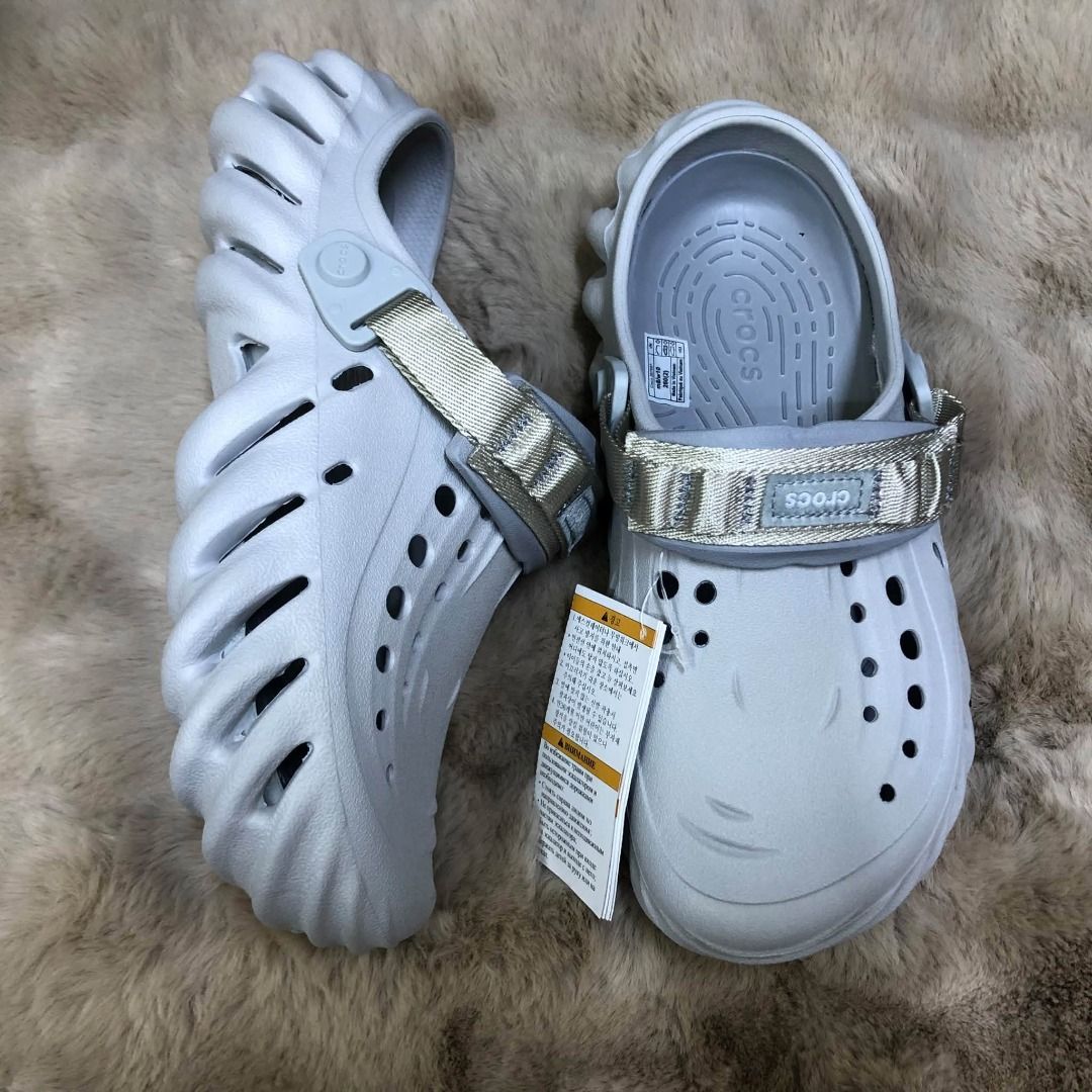 Crocs Echo Clog Multiple Colors Available (Category: Slippers & Slides) located in Manila. Submitted by khielnatha93179 (Listing ID 1466789926, Image 1). Description: Crocs Echo Clogs, multiple colorways available including grey, black, cream, and brown. Unique sculpted design with ventilation holes. Adjustable nylon strap across the top with Crocs branding patch. Lightweight molded Croslite construction. Chunky futuristic aesthetic. Tags attache