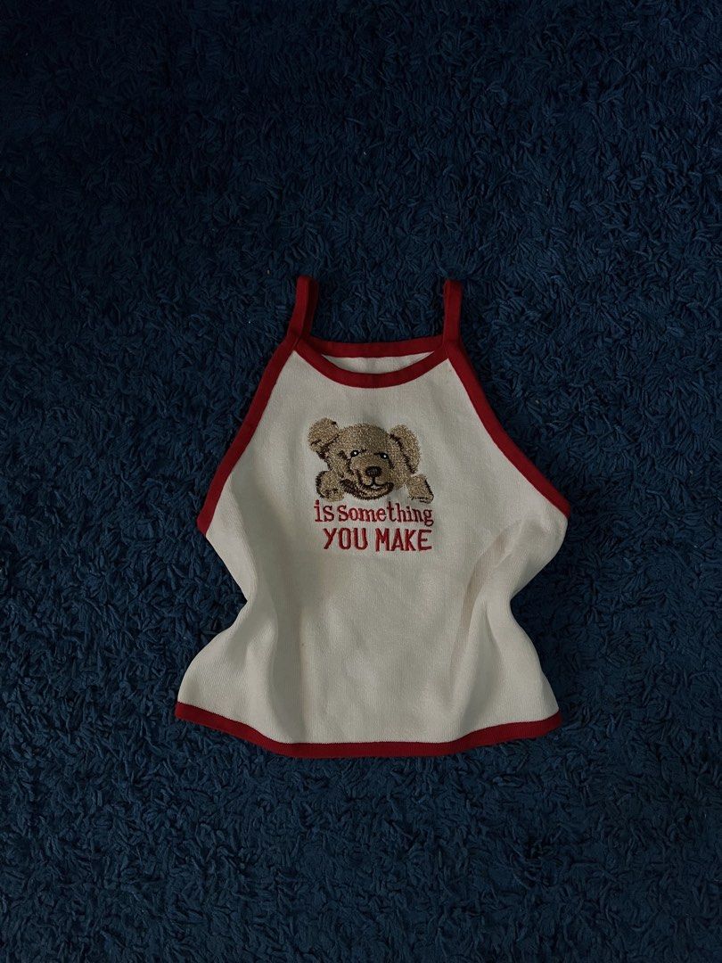 Cute bear embroidered spaghetti strap crop tank top (Category: Sleeveless) located in Plaridel. Submitted by vastwhale_38f456 (Listing ID 1466777528, Image 1). Description: - White knit tank top with bold red trim and thin spaghetti straps - Features a cute embroidered teddy bear patch with 'is SOMETHING YOU MAKE' red text - Flattering flared hemline - Great for casual summer days, out-of-town trips, or layering - Mode of Payment: GCash, maribank