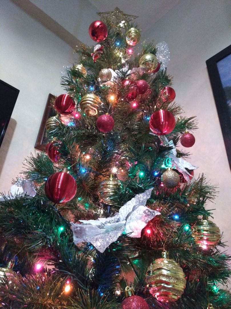 Decorated Artificial Christmas Tree with Ornaments and Lights (Category: Artificial Plants & Flowers) located in Pasig City. Submitted by kathee88 (Listing ID 1465931159, Image 1). Description: - Type: Fully decorated artificial pine Christmas tree - Ornaments included: Red & gold baubles, silver poinsettia flowers, and a gold star topper - Lighting: Pre-lit with multi-colored fairy lights - Size/Fit: Compact design, fits nicely in any living roo