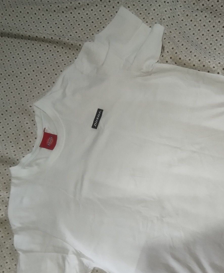 Dickies White T-shirt with Logo Patch (Category: Tshirts & Polo Shirts ) located in Manila. Submitted by lene48 (Listing ID 1466861447, Image 1). Description: - Brand: Dickies - Color: Plain White - Style: Short-sleeve crew neck tee - Details: Small black brand patch on chest, red Dickies neck label, and red woven tag near bottom hem - Fit: Classic everyday basic - Condition: Excellent / Good as new - Perfect for casual daily wear.