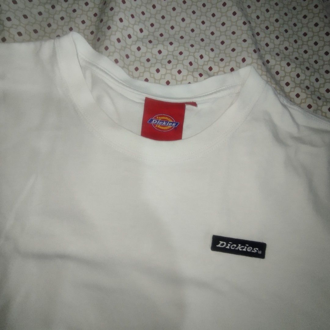 Dickies White T-shirt with Logo Patch (Category: Tshirts & Polo Shirts ) located in Manila. Submitted by lene48 (Listing ID 1466861447, Image 3). Description: - Brand: Dickies - Color: Plain White - Style: Short-sleeve crew neck tee - Details: Small black brand patch on chest, red Dickies neck label, and red woven tag near bottom hem - Fit: Classic everyday basic - Condition: Excellent / Good as new - Perfect for casual daily wear.