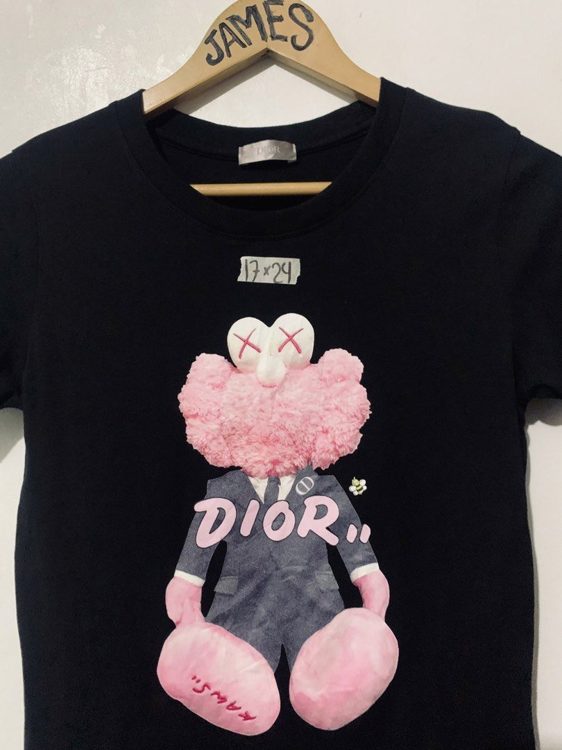 Dior x Kaws Black Pink Graphic Tee (Category: Tshirts & Polo Shirts ) located in Manila. Submitted by tanjames.14 (Listing ID 1466891497, Image 2). Description: - Brand: Dior - Design: Iconic pink Kaws character graphic on black tee - Size: Large (Tag says L, measures 17" x 24" flat) - Material: Premium cotton blend, Made in Italy - Style: Crewneck, short sleeve - Condition: Excellent, ready to wear - Mode of Payment: GCash, BPI, or Maya - Shippi