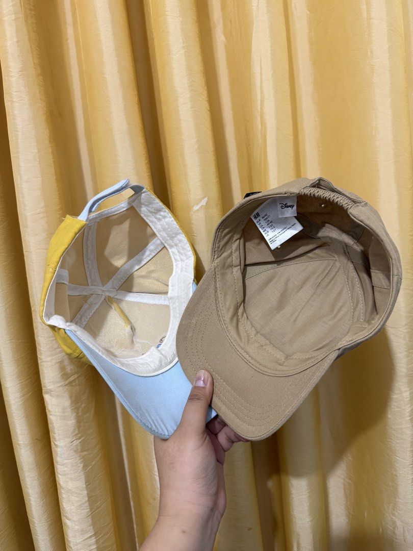 Disney Mickey Mouse and Yellow Sun Kids Caps Bundle (Category: Caps & Hats) located in Binan City. Submitted by prelovedlagunaph (Listing ID 1466968208, Image 2). Description: - Bundle of 2 toddler caps for daily wear - Cap 1: Beige H&M Mickey Mouse embroidered cap, Size 1-2Y with an elastic back strap for an easy fit - Cap 2: Bright yellow and light blue cap featuring a cute cartoon sun and playful ear details - Condition: Clean inside and out, 