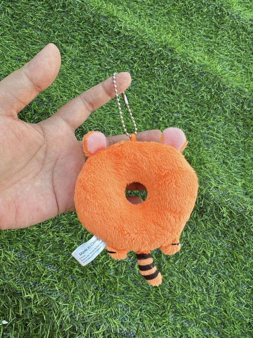 Disney Tigger Donut Plush Keychain Bag Charm (Category: Plushies & Soft Toys) located in Manila. Submitted by ronoarabbit.ph (Listing ID 1466873263, Image 2). Description: - Authentic Disney Tigger plush keychain shaped like a sweet donut - Features bright orange fabric with embroidered black tiger stripes and Tigger's signature - Detailed with cute little ears, a striped tail, and a secure ball chain - Official Disney tag attached; Made in China