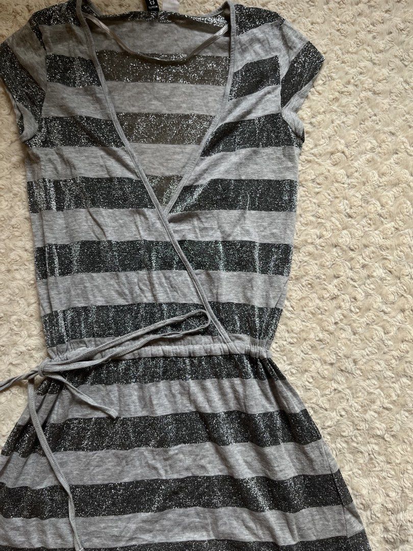 Divided by H&M Grey Striped Sparkle Tie Top (Category: Dresses) located in Mandaluyong City. Submitted by namislounge (Listing ID 1466928545, Image 3). Description: Fits xs-small - Style: Grey & black striped wrap dress with subtle metallic silver sparkle - Design: V-neck front, short cap sleeves, adjustable drawstring waist - Fabric: Lightweight knit with stylish sheer panels on top - Made in Turkey - Condition: Great piece for casual nights out