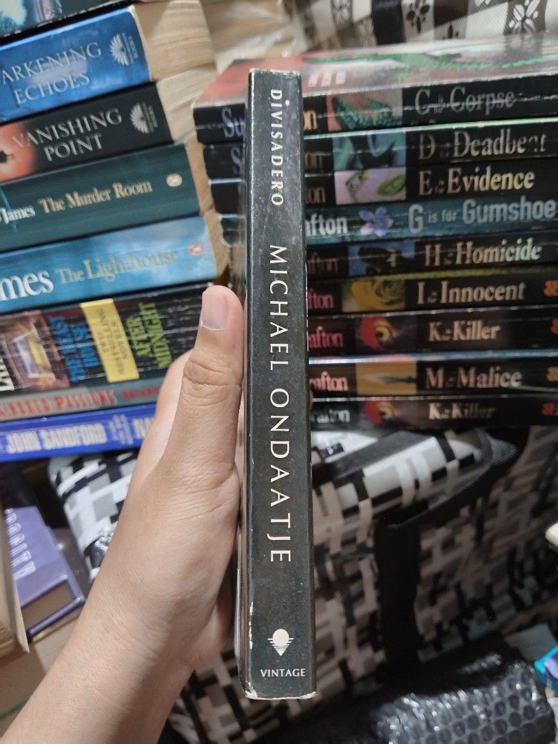Divisadero by Michael Ondaatje (Mmpb) (Category: Storybooks) located in Taguig. Submitted by booksbynini (Listing ID 1466949350, Image 2). Description: - Title & Author: Divisadero by Michael Ondaatje - Publisher: Vintage International (Random House) - Format: Softcover (Mmpb) - Condition: Pre-loved with standard shelf wear on edges and corners; pages have yellowish aging and spotting throughout - ISBN: 978-0-307-38975-6.
