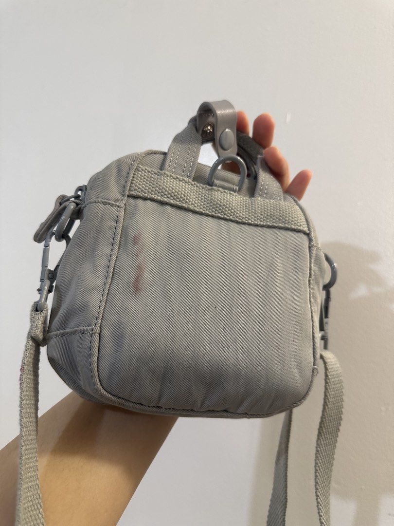 Doughnut Grey Mini Backpack Crossbody Bag (Category: Backpacks) located in Makati City. Submitted by cosmicfire.4ba272 (Listing ID 1466929349, Image 3). Description: - Brand: Doughnut - Type: Mini backpack style crossbody bag - Color: Grey - Features: Front flap pocket with branded patch and dual snap buttons, top grab handles, adjustable webbed shoulder strap, main zip compartment, and inner slip pocket - Flaws: Small reddish stain on the back e
