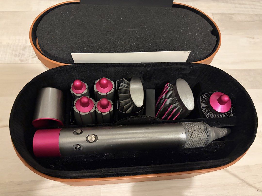Dyson Airwrap Multi-Styler Complete (Category: Hair) located in Angeles City. Submitted by boutique289715 (Listing ID 1466950135, Image 1). Description: - Authentic Dyson Airwrap multi-styler in striking Nickel and Fuchsia - Complete set includes multiple barrels, smoothing brushes, round volumizing brush, and pre-styling dryer - Comes with the original tan presentation case (exterior shows minor scuffs and wear marks) - Fully tested and in great