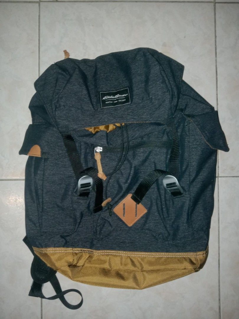 Eddie Bauer Heather Grey and Brown Backpack (Category: Backpacks) located in Manila. Submitted by antonsnchz (Listing ID 1466829380, Image 1). Description: - Brand: Eddie Bauer - Color: Heather grey with brown bottom panel - Closure: Drawstring under main flap with dual buckle straps - Pockets: Front zipper pocket with leather pull tab - Comfort: Padded mesh back panels and adjustable shoulder straps - Condition: Clean interior, sturdy constructi