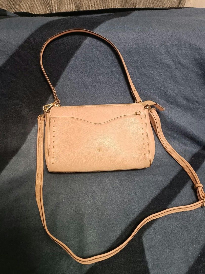 Elegance shoulder/sling convertible bag (Category: Cross-body Bags) located in Manila. Submitted by reneemaygo42069 (Listing ID 1466881891, Image 2). Description: - Color: Nude pink - Material: Textured leatherette with gold-tone hardware - Closure: Secure zip top - Pockets: Front slip pocket with delicate gold stud detailing - Branding: Small gold logo emblem on the front - Straps: Dual straps included (short shoulder strap and long adjustable c