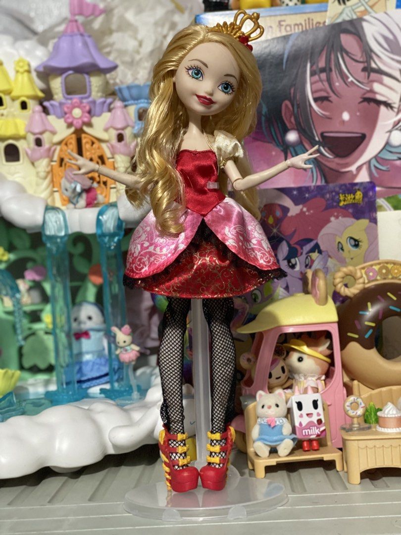 Ever After High Apple White Doll (Category: Kids Toys) located in Manila. Submitted by deniseeverafter (Listing ID 1466846297, Image 2). Description: - Character: Apple White from Ever After High - Hair & Face: Long blonde curled hair and blue eyes - Accessories: Gold crown headpiece and clear display stand included - Outfit: Red bodice, pink and red layered skirt, black fishnet tights, and red strapped heels - Condition: Clean hair and outfit, w
