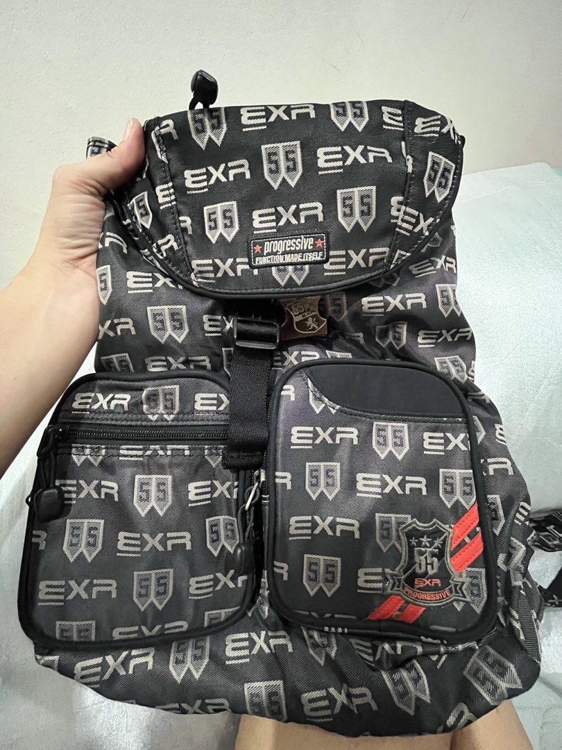 EXR Progressive Monogram Black Backpack (Category: Backpacks) located in Talisay. Submitted by cherylu (Listing ID 1466921070, Image 3). Description: EXR black backpack, monogram print all over with 55 logo patches. Front flap with a metal buckle closure plus twin front zip pockets with drawstrings. Inner lining has matching EXR pattern with a zipped pocket inside. Adjustable shoulder straps on the back. Sturdy hardware and durable fabric constru