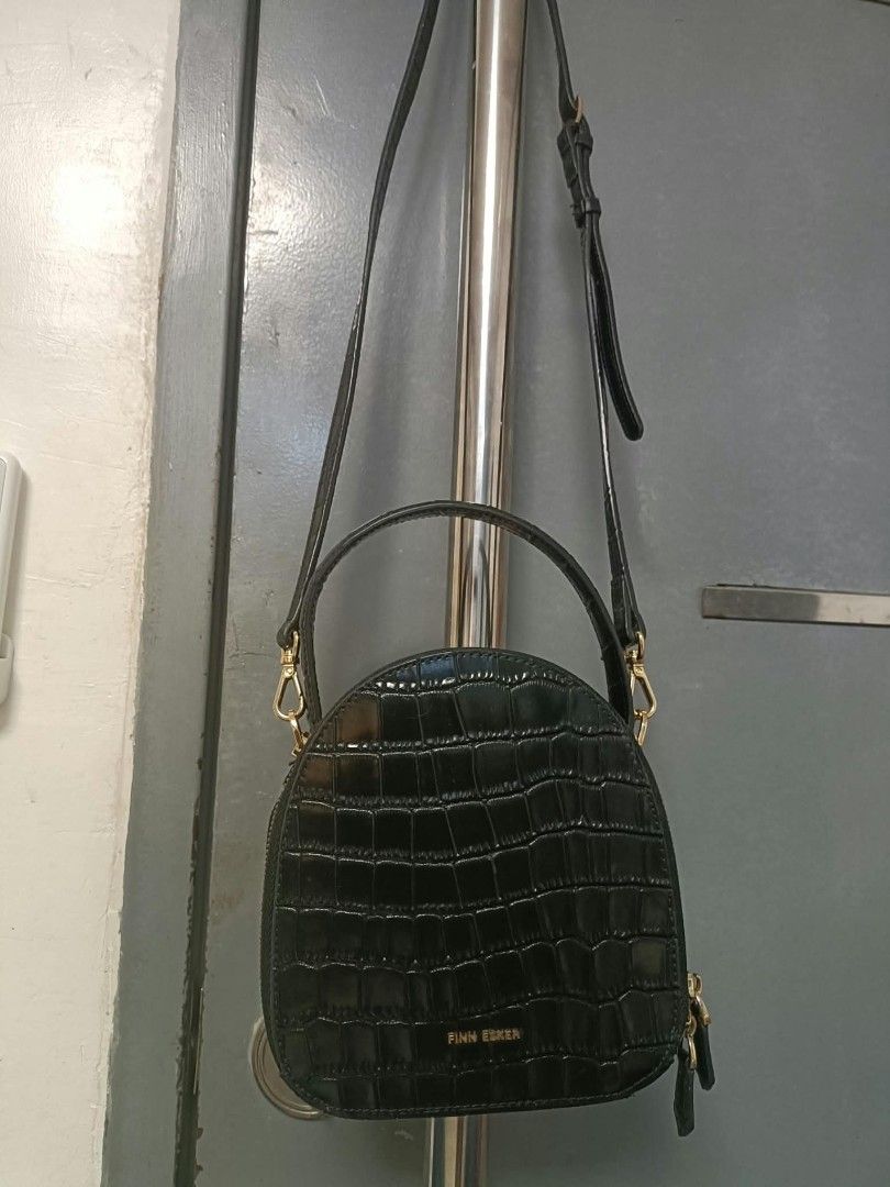 Finn Esker Black Crocodile Pattern Crossbody Handbag (Category: Cross-body Bags) located in Manila. Submitted by reneemaygo42069 (Listing ID 1466882776, Image 1). Description: - Brand: Finn Esker - Style: Rounded dome handbag with chic all-over crocodile pattern texture - Color: Classic Black with elegant gold-toned hardware - Closure: Secure dual zip-around closure - Details: Subtle gold logo lettering stamped on the front - Straps: Convenient t