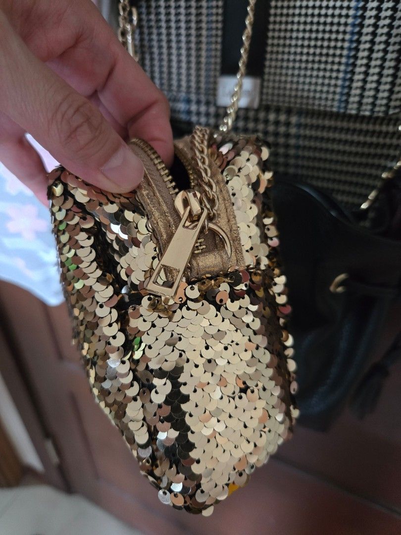 Forever 21 Gold Sequin Crossbody Bag (Category: Cross-body Bags) located in Quezon City. Submitted by mgdeclutters (Listing ID 1466802379, Image 3). Description: - Brand: Forever 21 - Design: Fully covered in sparkling gold sequins - Closure: Secure top zipper - Strap: Stylish metal chain strap - Interior: Black fabric lining with brand tag - Size: Compact, ideal for parties, events, and nights out.