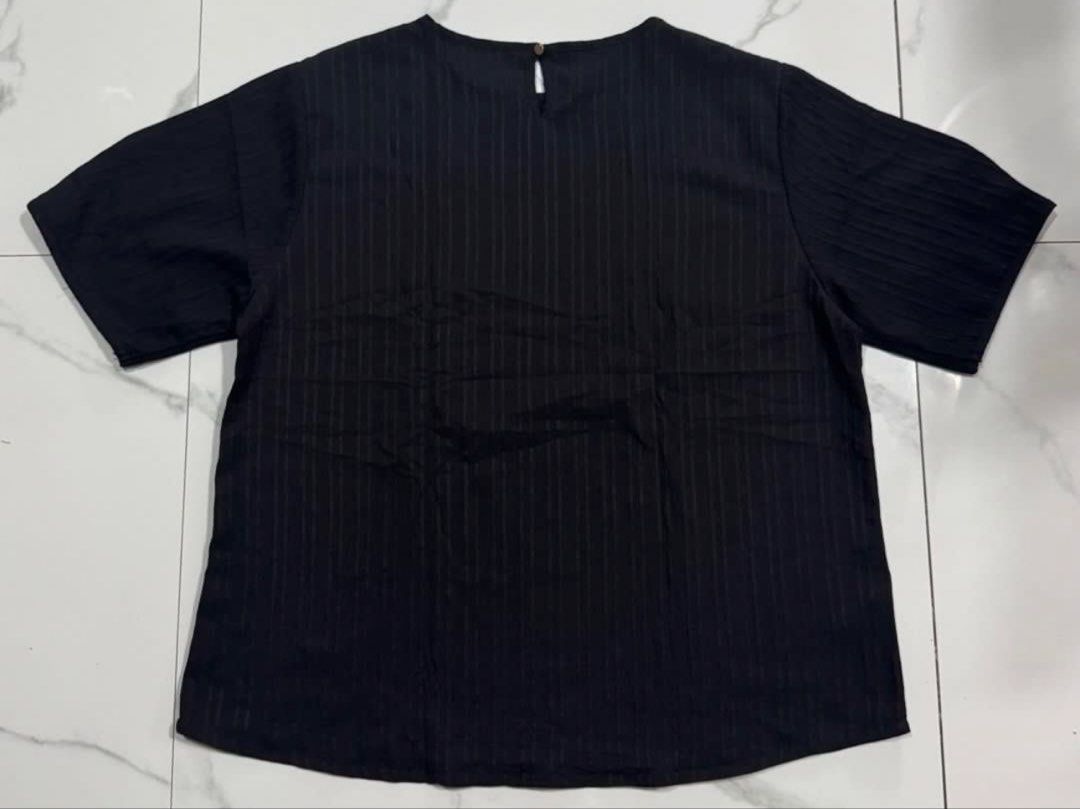 FREEGO Black Textured Short Sleeve Blouse (Category: Blouses) located in Pasay City. Submitted by szepter (Listing ID 1466793330, Image 2). Description: - Brand: FREEGO - Color: Neutral black - Style: Short-sleeve top with textured striped fabric, round neckline, and back keyhole button closure - Fit: Regular fit, straight hemline - Measurements (laid flat): Pit-to-pit ~25 inches, Length ~24 inches - Condition: Great everyday basic - Versatility:
