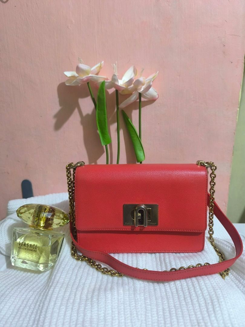 Furla red leather chain shoulder bag (Category: Luxury Bags & Wallets) located in Cebu City. Submitted by re-amoreph_2014 (Listing ID 1466958299, Image 1). Description: - Brand: Furla - Material: Bright red textured leather - Hardware: Gold-tone hardware with engraved metal clasp - Strap: Matching chain strap with a comfortable leather shoulder section - Interior: Clean and spacious - Design: Classic flap closure and structured shape - Style: Gre