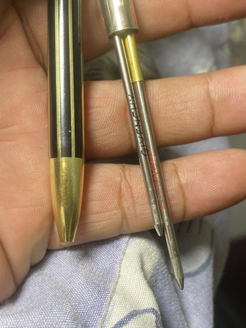 Givenchy Black and Gold Ballpoint Pen (Category: Stationery & School Supplies) located in General Trias. Submitted by mangu_ukay (Listing ID 1466914572, Image 2). Description: - Authentic vintage Givenchy luxury ballpoint pen - Sleek black finish with elegant gold vertical stripes and gold trim - Iconic Givenchy 4G logo featured on the clip and cap top - Engraved Givenchy branding on the middle ring and refill cartridge - Reliable refillable twis