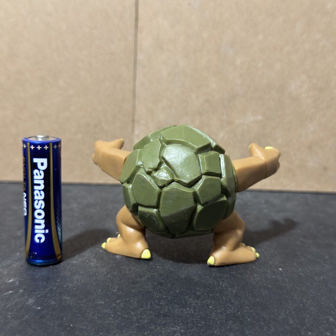 Golem Pokémon Figure 2007 Jakks Pacific (Category: Figurines & Statues) located in Cuyapo. Submitted by blacksheepshop (Listing ID 1466786925, Image 3). Description: Grotle Pokémon figure from 2007. Made by Jakks Pacific. Green shell and brown body with articulated arms. Stands around AA battery height for scale. Backstamp reads Nintendo and Jakks China. Some minor paint wear on the claws, normal for loose vintage toys. Great piece for a Pokémon 