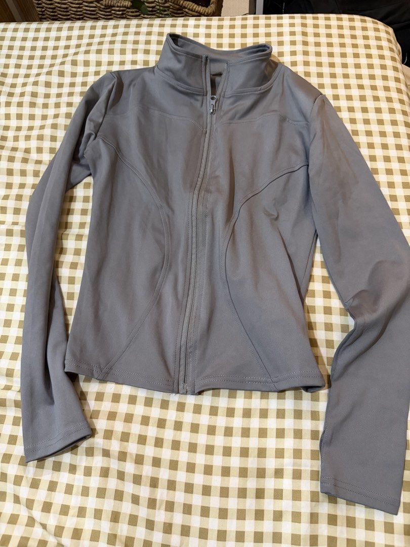 Grey Activewear Zip-Up Jacket with Thumbholes (Category: Activewear) located in Pasig City. Submitted by deedee235 (Listing ID 1466882630, Image 2). Description: - Colour: Grey - Style: Athletic zip-up jacket with high collar and contoured seams - Features: Long sleeves with thumbholes, full-length front zipper - Material: Smooth, stretchy fabric - Condition: Clean and ready to wear - Versatility: Great for workouts or casual everyday use.