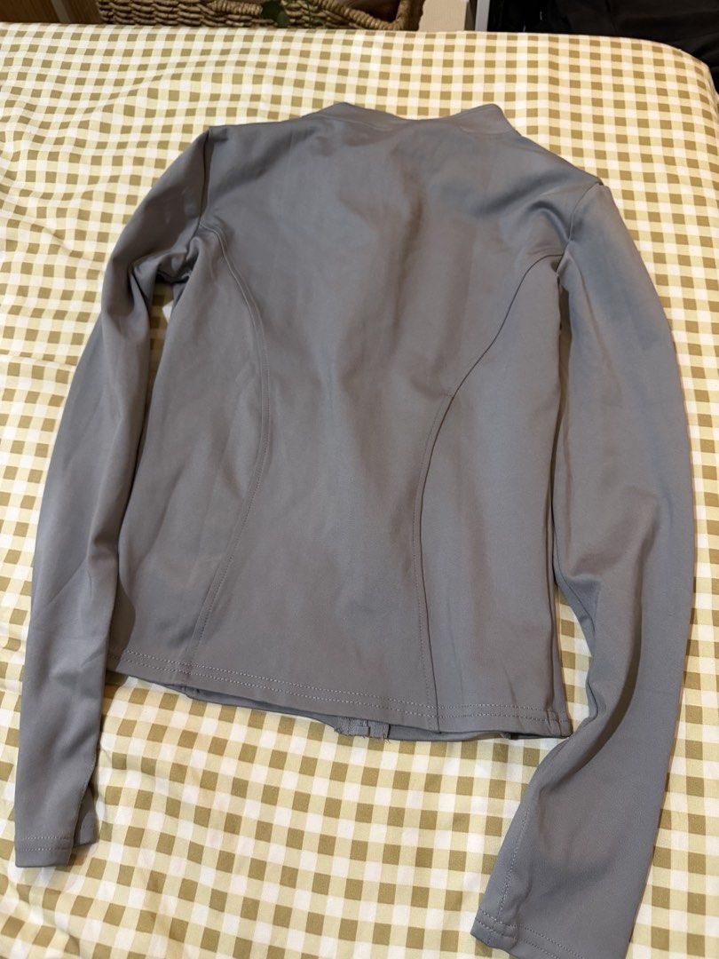 Grey Activewear Zip-Up Jacket with Thumbholes (Category: Activewear) located in Pasig City. Submitted by deedee235 (Listing ID 1466882630, Image 3). Description: - Colour: Grey - Style: Athletic zip-up jacket with high collar and contoured seams - Features: Long sleeves with thumbholes, full-length front zipper - Material: Smooth, stretchy fabric - Condition: Clean and ready to wear - Versatility: Great for workouts or casual everyday use.