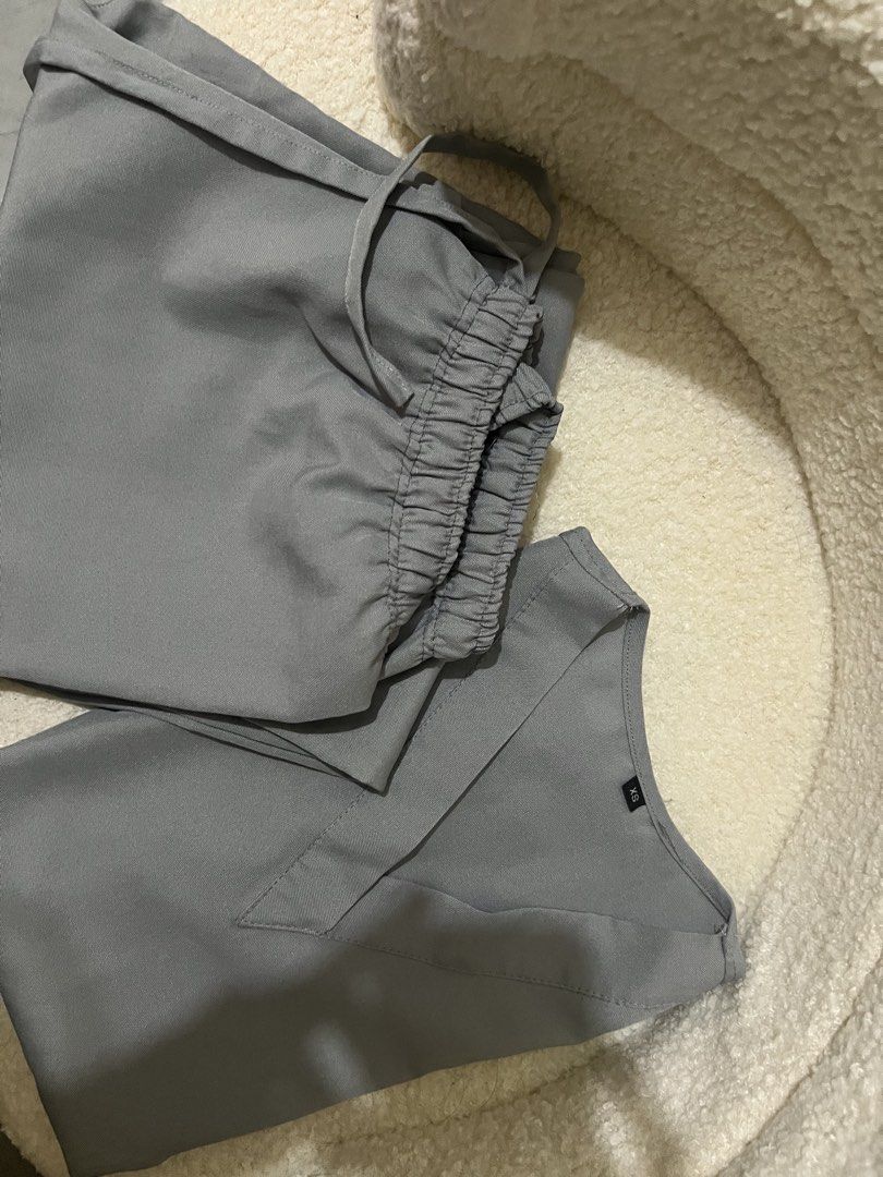 Grey Scrub Set V-Neck Top and Drawstring Pants Size XS (Category: Sets or Coordinates) located in Cabuyao City. Submitted by viaaino (Listing ID 1466835751, Image 1). Description: - Color: Grey - Size: Extra Small (XS) - Top: Short sleeve, V-neck - Bottoms: Drawstring pants with elastic waist - Fabric: Smooth and lightweight - Condition: Clean, folded, and ready for work.