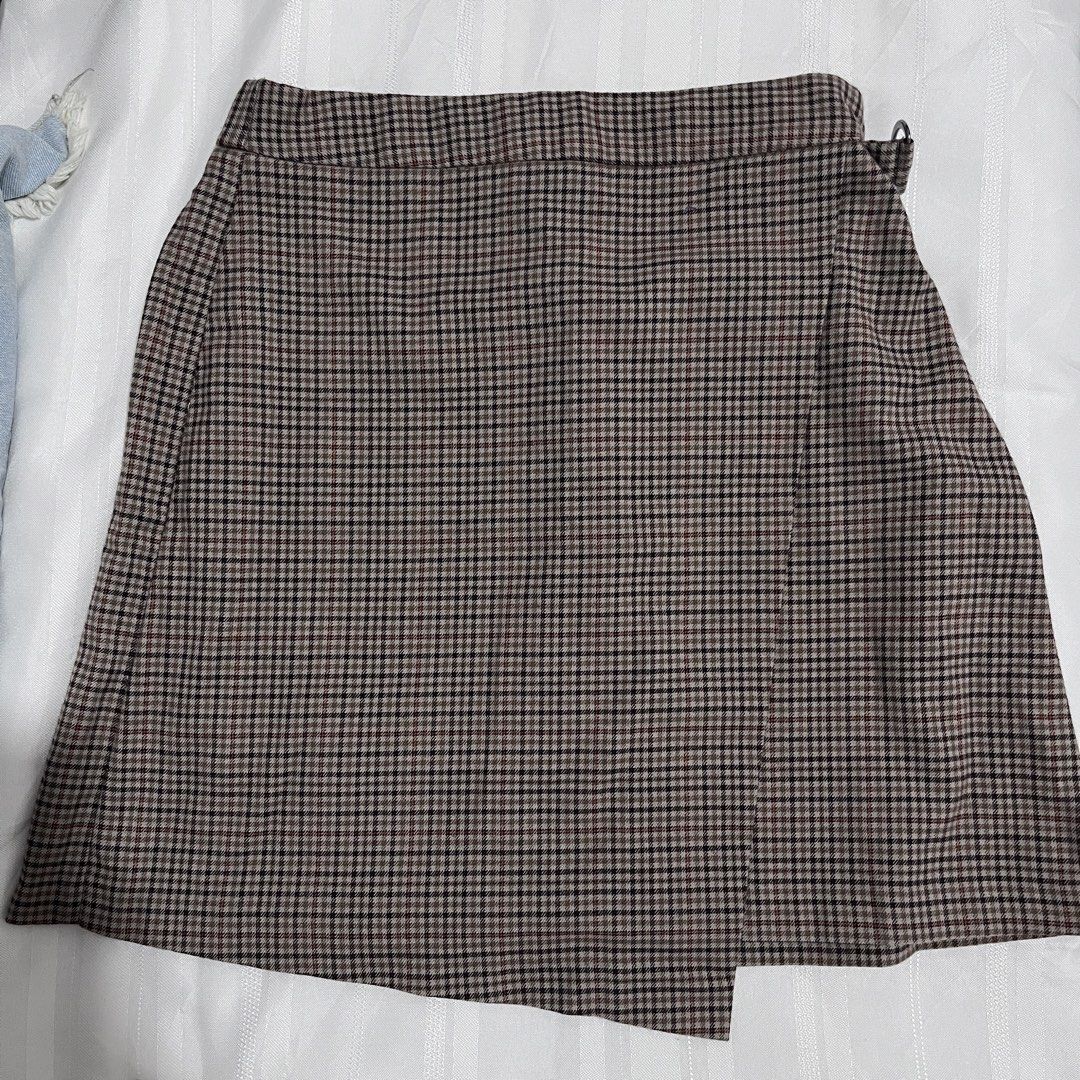 GU Brown Plaid Skort Size S (Category: Skirts) located in Baguio. Submitted by gbwardrobe (Listing ID 1466934879, Image 1). Description: - Brand: GU - Size: S - Material: 65% polyester, 33% rayon, 2% spandex for a comfortable stretch - Design: Asymmetric front wrap with built-in short inner lining - Pattern: Brown and black houndstooth check with subtle red grid lines - Style Code: 222-328498.