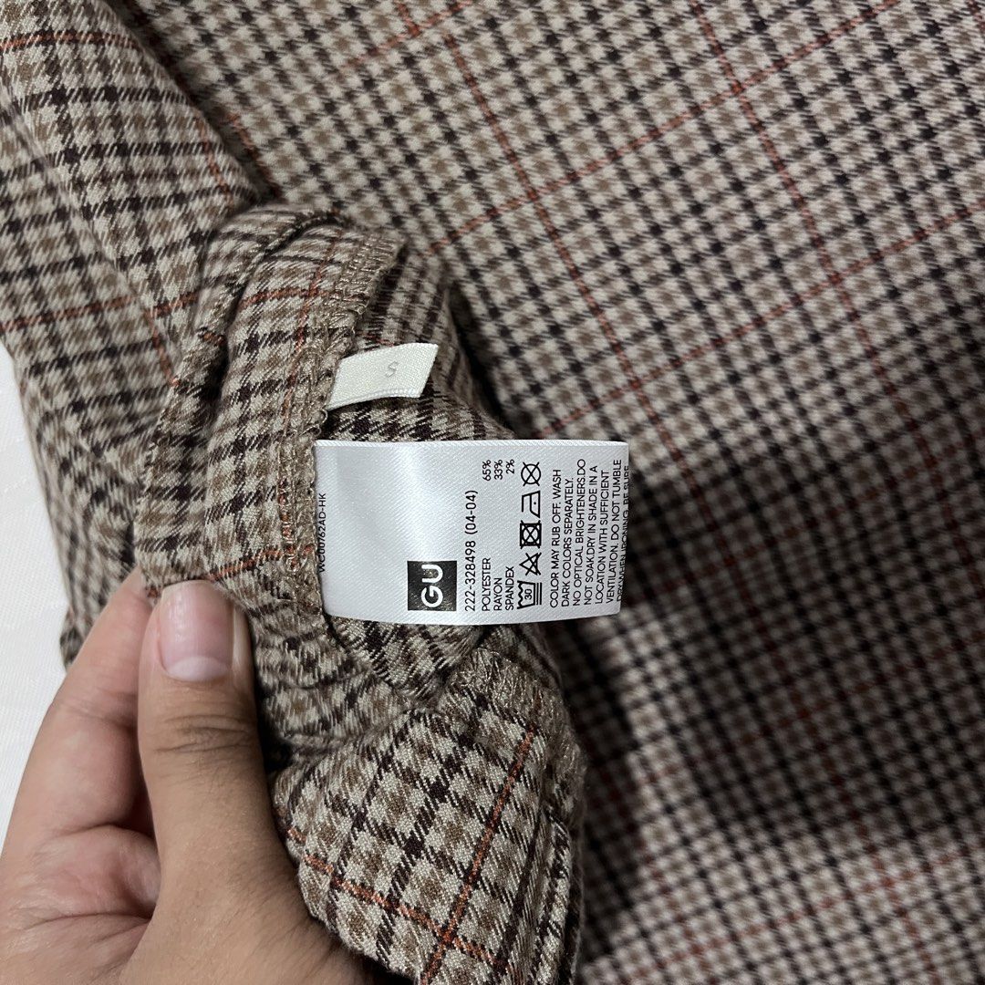 GU Brown Plaid Skort Size S (Category: Skirts) located in Baguio. Submitted by gbwardrobe (Listing ID 1466934879, Image 2). Description: - Brand: GU - Size: S - Material: 65% polyester, 33% rayon, 2% spandex for a comfortable stretch - Design: Asymmetric front wrap with built-in short inner lining - Pattern: Brown and black houndstooth check with subtle red grid lines - Style Code: 222-328498.