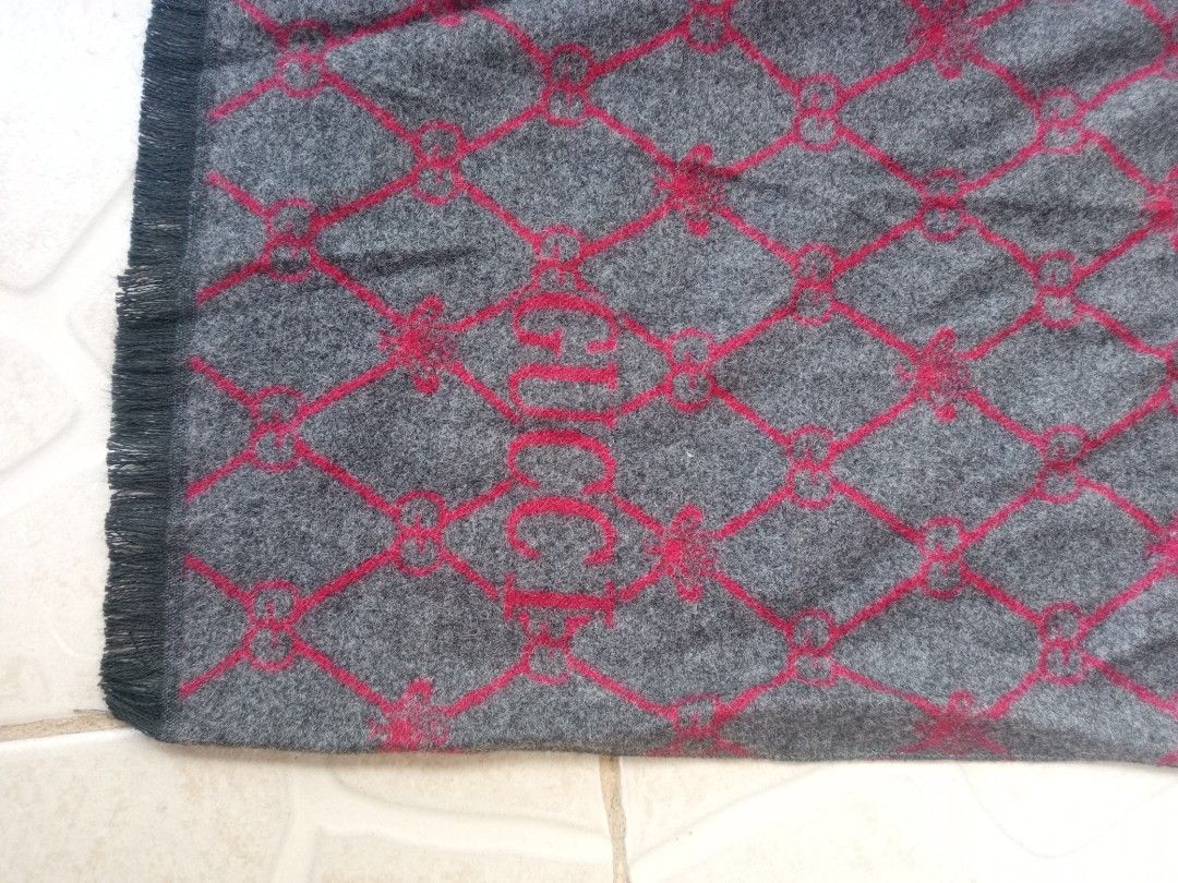 Gucci Diamond Monogram Bee Scarf Grey Red (Category: Luxury Apparel) located in Liloan. Submitted by dnznoon31 (Listing ID 1466857835, Image 2). Description: - Gucci scarf in stylish grey and red tones - Features a chic diamond lattice pattern with subtle interwoven bee graphics - Prominent Gucci lettering signature near the end - Soft fringed tassel trim along both short edges - Reversible two-tone design (grey on one side, red on the other) Dim