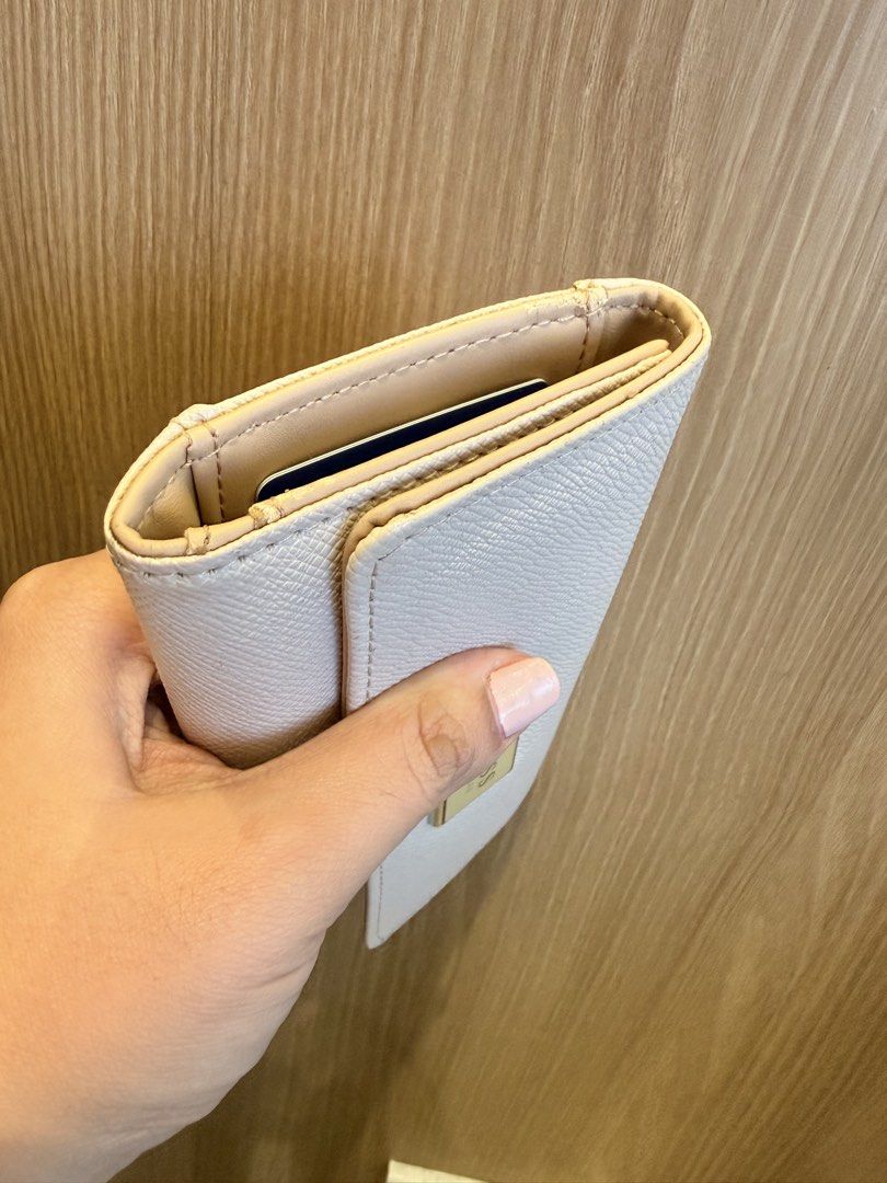 Guess Cream Long Wallet with Card Slots (Category: Wallets & Card holders) located in Manila. Submitted by angelcurated (Listing ID 1466809398, Image 2). Description: - Brand: Guess - Color: Cream (neutral tone that matches any outfit) - Material: Premium leather-textured finish - Hardware: Silver-tone front logo plate - Closure: Smooth snap button closure - Exterior: Convenient back zipped coin pocket - Interior: Multiple card slots and spacious