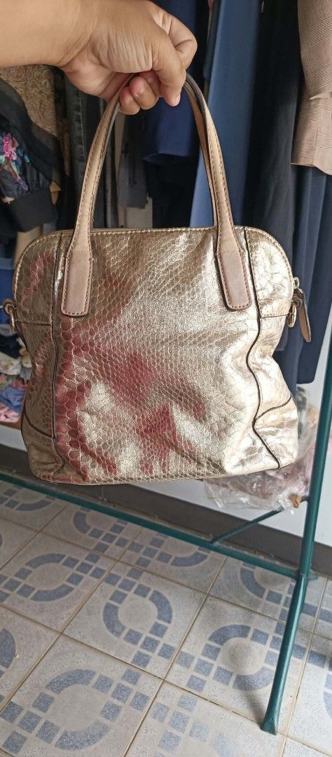 Guess Gold Metallic Snake Print Handbag (Category: Luxury Bags & Wallets) located in Dimasalang. Submitted by tinzstory (Listing ID 1466967980, Image 2). Description: Brand: GUESS Style: Metallic Gold Snakeskin Dome Satchel / Handbag Interior: Clean floral signature lining with zipper and slide pockets (No rips or major stains). Hardware: Shiny gold-tone hardware and iconic GUESS logo charms are fully intact. ⚠️ Condition Notes (Please Read Befor