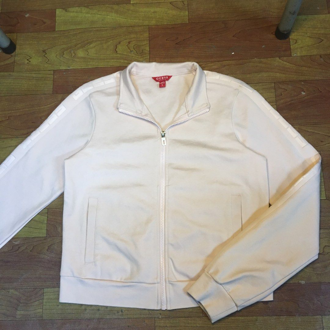 Guess light pink zip-up track jacket size S (Category: Coats, Jackets and Outerwear) located in Zamboanga. Submitted by yuriwantscreampie (Listing ID 1466874887, Image 1). Description: - Brand: Guess - Color: Light pink - Size: Small - Design: Full zip front with high collar - Details: Tape detail with printed branding along both sleeves - Features: Ribbed cuffs and hem, two front welt pockets - Authenticity: Red Guess tag inside at the collar.