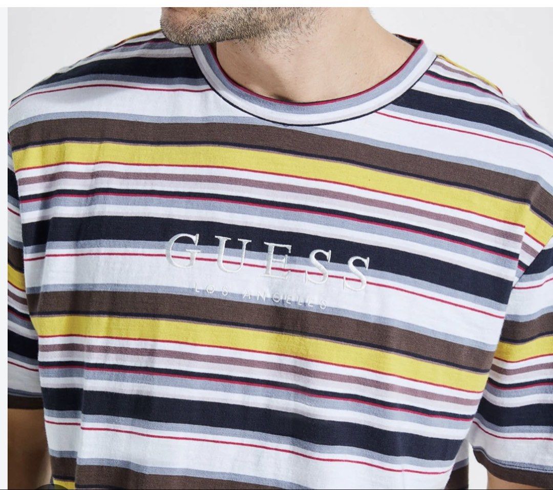 Guess Tshirt 2 for 450 (Category: Tshirts & Polo Shirts ) located in Pasig City. Submitted by thevintagenook (Listing ID 1466906584, Image 1). Description: - Brand: Guess Los Angeles - Design: Multi-color horizontal stripes (white, yellow, brown, and dark blue) - Branding: Embroidered Guess logo across the chest - Fit/Style: Classic crew neck, short sleeves, casual streetwear - Versatility: Super easy to match with denim and everyday casual fits.