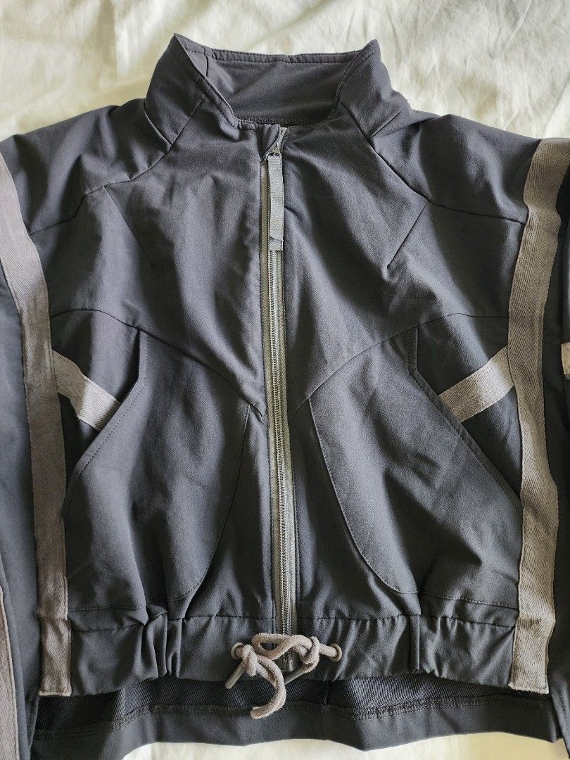 Gymshark Black Cropped Jacket Size S (Category: Coats, Jackets and Outerwear) located in Cebu City. Submitted by groovefunknsoul (Listing ID 1466851788, Image 3). Description: - Brand: Gymshark - Style: Cropped zip jacket - Color: Black with grey contrast taping - Size: Small - Features: Full zipper, drawstring adjustable waist, long sleeves with banded cuffs, 2 front pockets, 1 small sleeve pocket - Detail: Gymshark branded woven loop at the bac