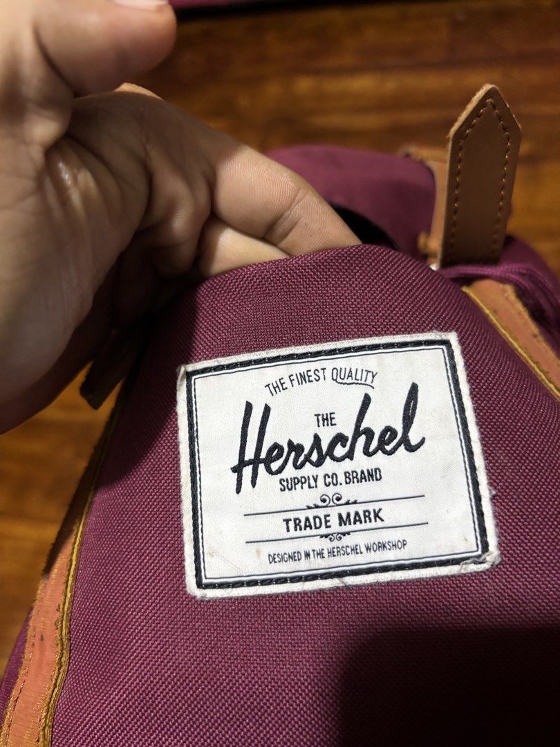 Herschel Maroon Backpack with Brown Straps (Category: Backpacks) located in Malaybalay. Submitted by ziggyy. (Listing ID 1466865472, Image 3). Description: - Authentic maroon Herschel backpack - Features durable canvas material with brown faux leather straps and metal buckles - Secure drawstring closure under the main flap - Signature red and white striped fabric interior lining - Adjustable, padded shoulder straps for all-day comfort - Clean ext