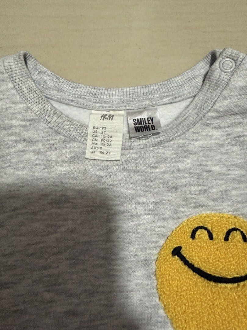 H&M SmileyWorld children's sweatshirt (Category: Babies & Kids Fashion) located in Quezon City. Submitted by andanel16 (Listing ID 1466846884, Image 3). Description: H&M SmileyWorld children’s sweatshirt featuring a textured yellow smiley face patch on the chest. Kids Clothes Declutter/ Preloved Baby Boy Clothes (24 mos) These are preloved/declutter items, so please manage your expectations. Minor signs of use may be present due to previous wear.