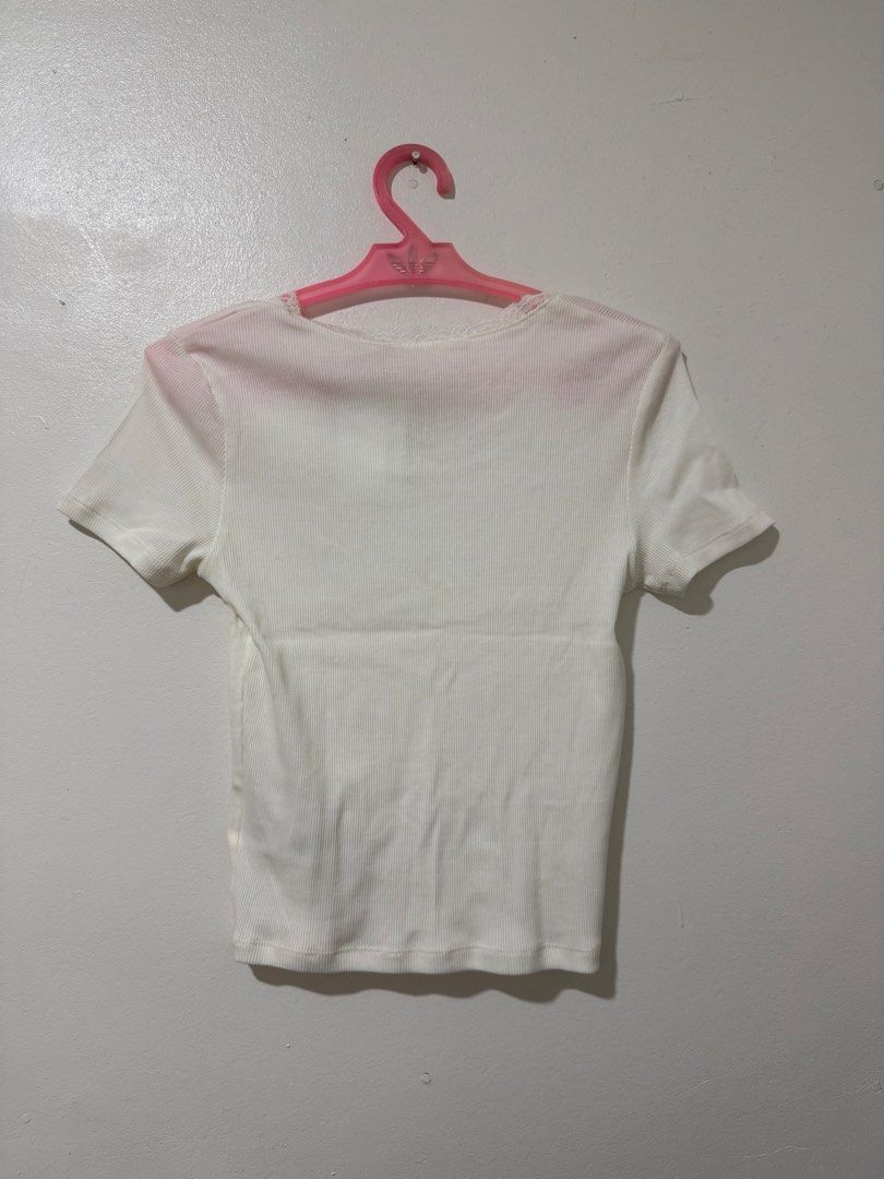 H&M White Ribbed Lace Trim Top (Category: Shirts) located in Manila. Submitted by itsmerawrs (Listing ID 1466789318, Image 2). Description: - Brand: H&M (Tag still attached) - Color: Clean white - Material: Soft and stretchy ribbed fabric - Fit: Fitted cut with short sleeves - Details: Scalloped lace trim on round neckline with a tiny center bow accent - Condition: Brand new, no stains or flaws.